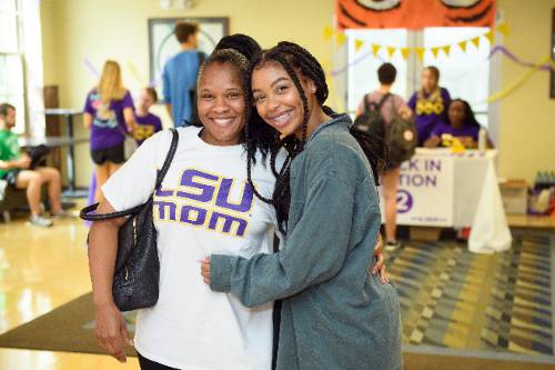 LSU student standing with mom in an LSU mom shirt