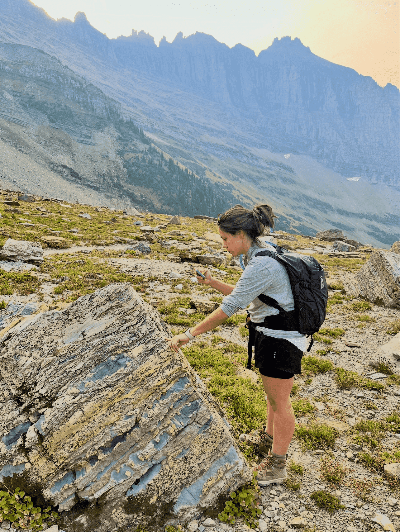 A student in the field looking at a rock formation